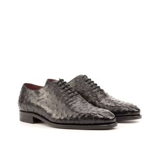 Black ostrich leather whole-cut oxford shoes with lace-up closure and leather soles.