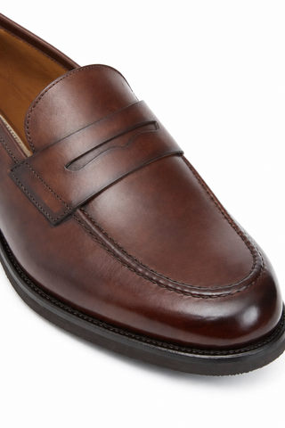 Bruno Magli Delfino brown hand-painted calf-skin leather penny loafer with a rounded toe and durable rubber sole.